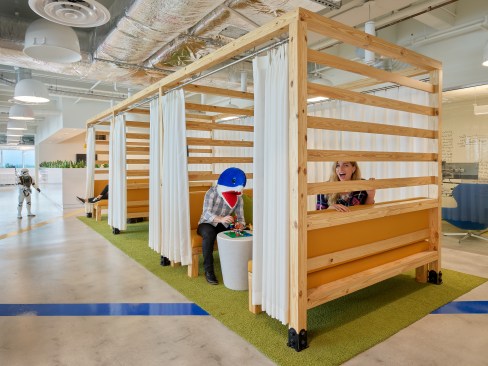 Pool cabana-style “hang out” spaces with orange benches and white curtains.