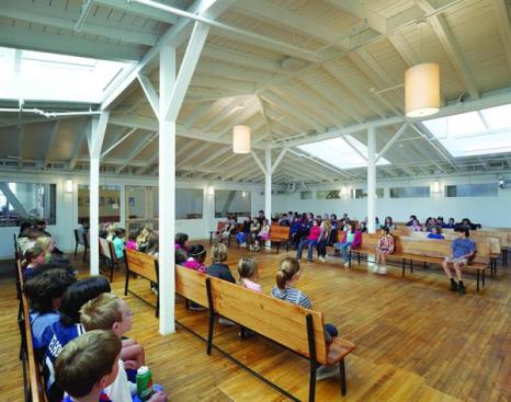 The meeting room is a place where the students and faculty come to engage in the Quaker tradition of silent reflection.  Located at the center of the second floor of the three-story building, the room actually has skylights because the roof of this central section is over the second story; windows on the doughnut-shaped third floor look down onto this lower roof.  The skylights had been covered when the factory was still in operation, but they were restored and upgraded to flood the room with light. Now each skylight is fitted with a mechanism that is connected to the building's direct digital-control building management system, and the skylights authomatically open and close to regulate temperature and draw air through the space. Interior windows on the perimeter of the room bring additional daylight to the second-floor corridors.
