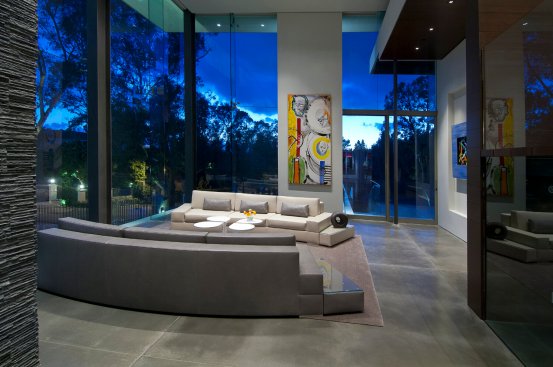 Modern luxury Beverly Hills home living room with energy efficient double height glass walls. 