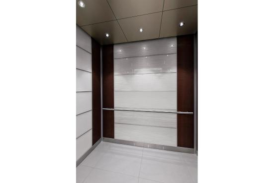 LEVELe-102 Elevator Interior with rear wall main panels in ViviGraphix Graphica glass with Cairo interlayer and Standard finish; side wall main panels in ViviChrome Chromis glass with White interlayer and Opalex finish; accent panels in American Cherry with Dark Mahogany Stain wood veneer; Round Handrail at Sallie Mae, Newark, Delaware