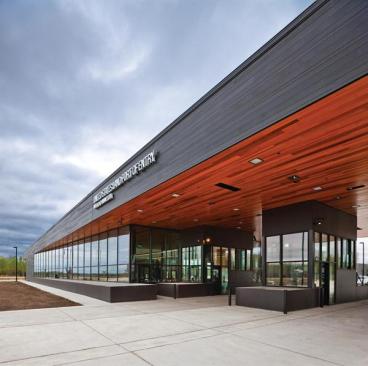 The exterior cedar siding is finished in a black stain, while the underside of exterior canopies and the interior ceilings of public and office space are finished in a natural stain.