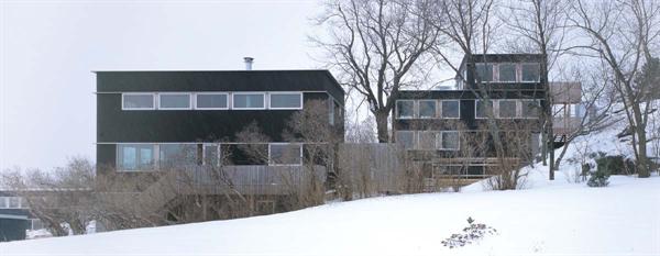 Existing rock ledges unify the three houses and make them part of something larger than property lines.