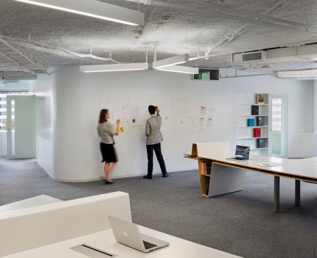 Three-pronged light fixtures mark the area over the Radar Desk; the walls are lined with white board paint to allow for idea generation.