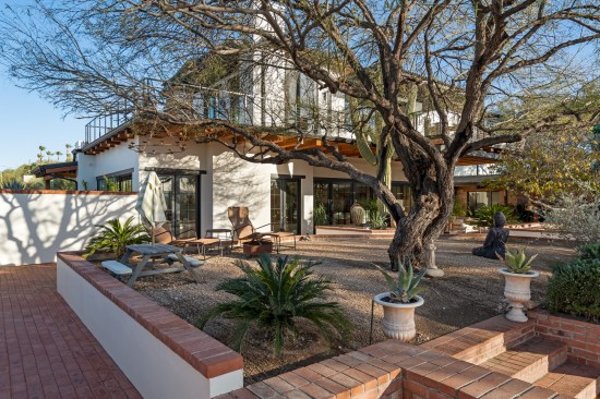The reimagined space integrates pathways, seamlessly merging the new and old areas for a harmonious transformation. The backyard features a mature Mesquite tree, a cherished part of the property's history. A cozy fire pit, accompanied by comfortable seating, beckons for moments of relaxation. The addition of red brick pathways adds a touch of timeless charm to this outdoor haven.