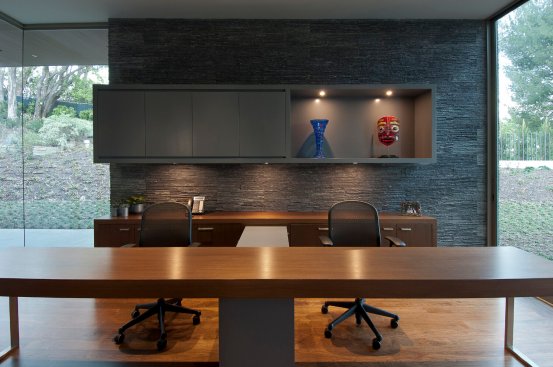 Beverly Hills modern home office with stacked slate wall and elongated wooden desk.