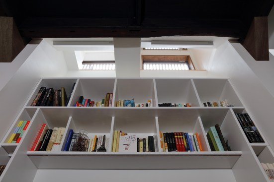 Natural light from the upstairs windows and clerestory windows filters into the downstairs space through the floor opening/shaft space.