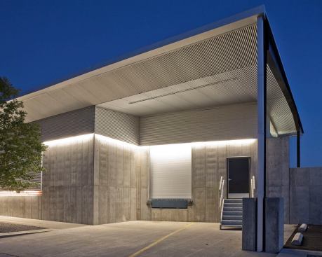 The loading dock is illuminated by fluorescent strip lighting fully integrated into the building skin.