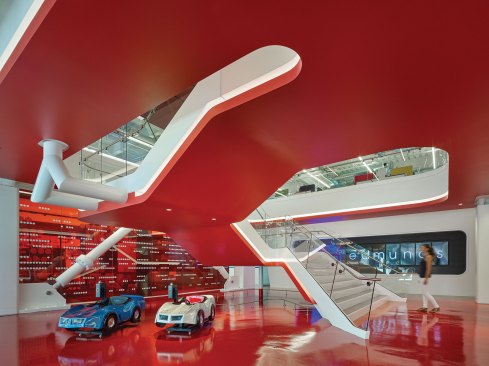 The U-shaped floating stair features a concealed LED cove to evoke the idea of a car's racing stripes and nighttime striplighting on highways.