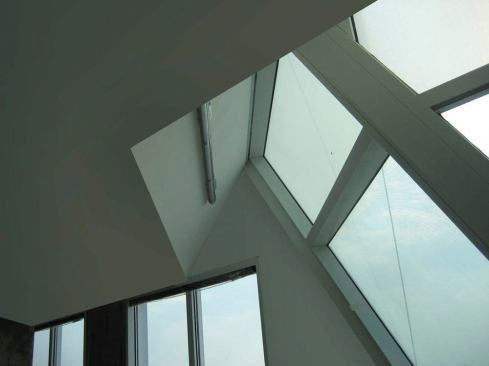 At the narrow windows inside the offices that surround the protruding core, 3000K LED narrow beam wall grazers illuminate the translucent fritted glass from within.