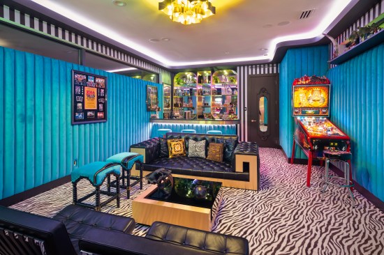 Zebra carpet and turquoise walls create a fun vibe in this game room.
