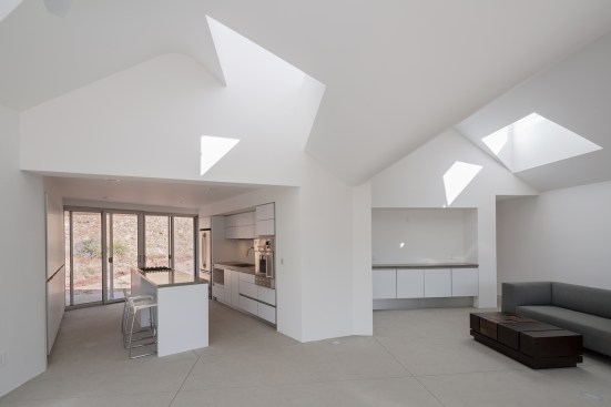 The chimneys that punctuate the roofline help ventilate the main living space (pictured) and other interiors, and they also bring natural light into the house through clerestory windows.