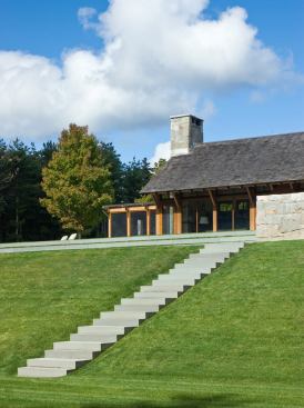 A minimalist stair of precisely laid stone descends the south-facing slope from the house.