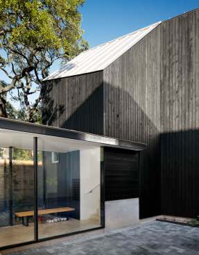 The addition and existing house are connected by a glass "bridge."