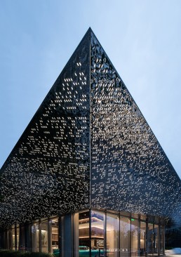 Punctures in the canopy’s rippling, silver surface allows light shine through at night.