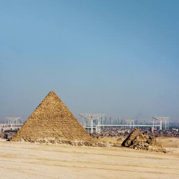 The pyramids of Giza with, in the background, the new cultural pyramids above modern Cairo