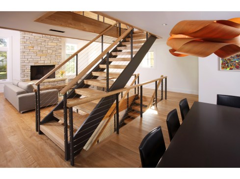 Great view of the stircase and living room (with fireplace) behind. Also shows the one-of-a-kind lighting fixture over the dining table