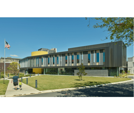 The western façade is reminiscent of books on a shelf, utilizing slender windows of varying widths and vertical fins to mitigate heat gain.  
 
