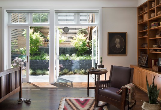 On the lower level, the new master bedroom takes advantage of the existing tall ceiling heights with a large expanse of windows and doors to visually connect to the garden and create a bright, airy space.