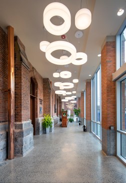 Interior view of the new accessible lobby and box office addition. The original façade is evident on the left. Addition finishes include brick, granite, cast stone, and polished concrete flooring.