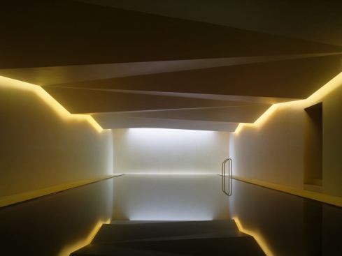 At night color-variable LEDs provide either a warm white glow or selected colors for dramatic ambiance. The perimeter light troughs provide almost all of the space's lighting, while preventing any light to penetrate the sculptural ceiling.