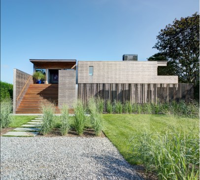 Strategic landscaping with indigenous plants alludes to the coastal ecosystem the home is set in.