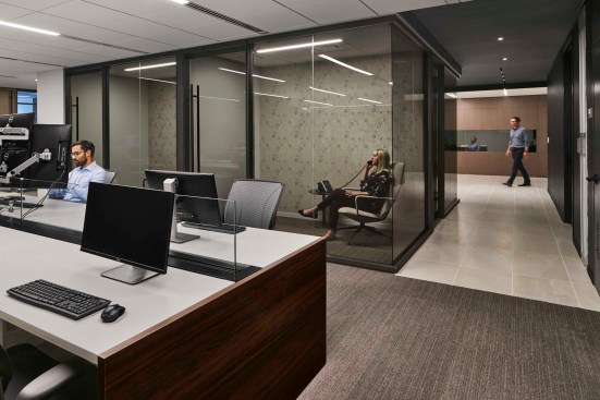 Bench systems in the open work areas accommodate the ever-changing composition of the company. Glass enclosed telephone rooms provide privacy as well as transparency.