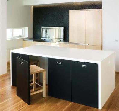The kitchen wall is solid black lava stone. The material reflects Icelands volcanic topography and suggests a kind of black box theater for the owners live work space. 