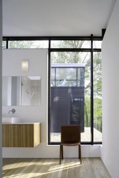 In contrast to the first floor, the second level of the home features light colored wood floors and cabinets. The master bathroom vanity uses a limestone top.