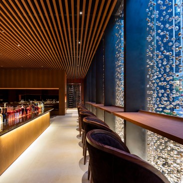 Entry into bar area at dusk with beaded curtain and highlighted central bar, Four Seasons Restaurant, New York