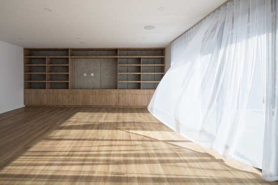 Oak floors and built-ins are used in each unit to bring warmth to the concrete. 