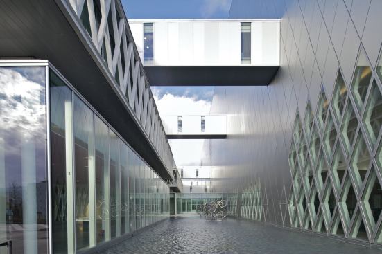 Between the two structures is a courtyard spanned by bridges that link the volumes at different levels. 
