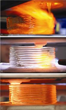 The printer method evolved from free-falling molten glass (A) to using a nozzle (B) in an annealing chamber (C).