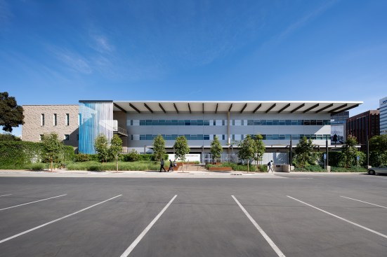 Exterior view, with exit stair screened with colorful steel wire at left