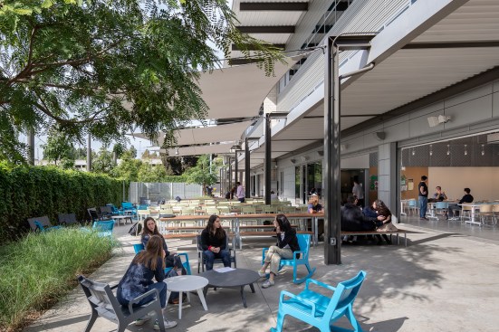 Outdoor seating on patio, with indoor multipurpose and dining area at right, beyond open roll-up door