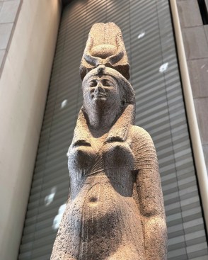 Colossal statues are situated within a varied and animated context.