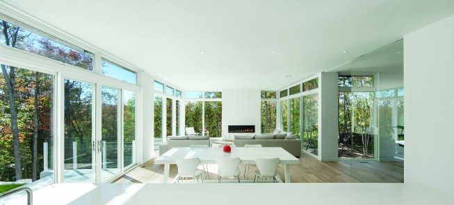 This Gatineau Hills home creates a beautiful balance between modern and natural. The natural house design embraces its earthy surroundings, while opening the door to a contemporary aesthetic. The open ground floor, with its interconnected spaces and floor-to-ceiling windows, allows sunlight to flow through uninterrupted, showcasing the beauty of the natural light as it varies throughout the day and by season.