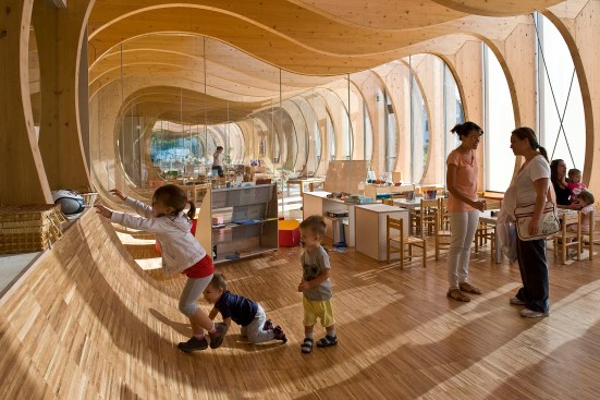 The curvature of the cutouts continues into the flooring, creating play surfaces for students.
