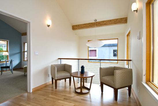 The upstairs sitting area overlooking the entryway features Berg & Berg 70% FSC-certified prefinished hardwood flooring.