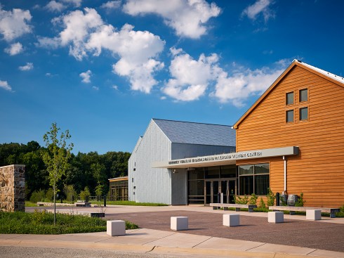 The visitor center entrance serves as the connection between two volumes, one clad in zinc and the other in cedar.