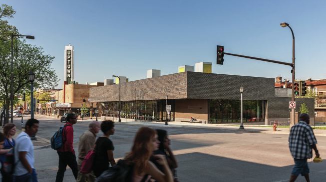 VJAA clad the building in stainless steel roof tiles that reflect the changing light. On the roof, light monitors with yellow-tinted glazing point in different directions to capture sunlight throughout the day.