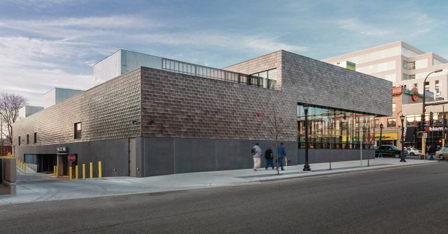 Basement parking is accessible from an alley on the west side.