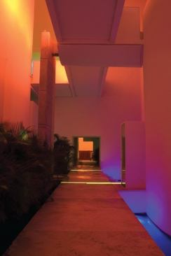 Warm tones of red, yellow, and orange light with accents of blue create a visual texture that responds to the architecture’s different surfaces.