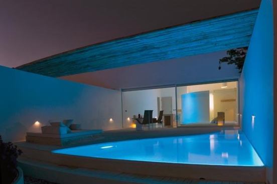 The architecture blurs the boundary between interior and exterior spaces. Each hotel room has its own private pool area, and the lighting helps to create a serene and relaxed environment for each guest.