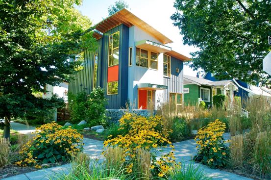 The lawn-free landscaping encompasses native plants and water-smart perennials, ornamental grasses, and permeable paving materials for driveways and walkways.