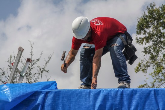 A roofer nails a furring strip and plastic sheeting into place on a Hurricane Irma-damaged roof in Sebring, Fla., as part of Operation Blue Roof, an initiative managed by the U.S. Army Corps of Engineers for FEMA.