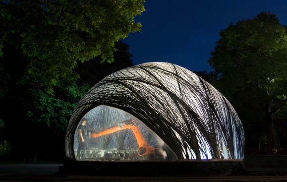 Fabricating the pavilion on site, the robotic armature extrudes bundles of carbon fiber and adhesive.