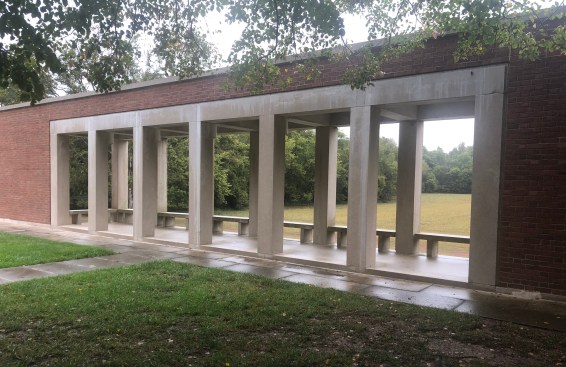 A small portico at the Roofless Church site frames views of the adjacent fields