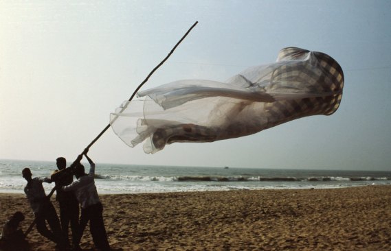 While a Fulbright Scholar in India, Echelman was inspired by the local fishing culture in the village of Mahabalipuran and she began experimenting with nets making temporary structures such as “Red Hot”. Made of cast bronze, sewn cotton net, Bhandini-dyed silk, and galvanized steel, the piece measures 65-feet-long by 11-feet-wide and tall.