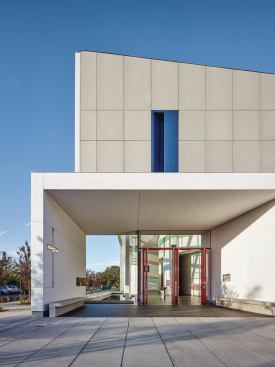 The east entrance brings visitors past a reflecting pool, which allows further play with light through custom window systems from All Weather Architectural Aluminum and Oldcastle BuildingEnvelope.