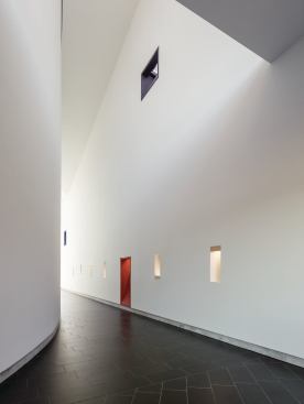 The hallways outside the sanctuary are punctuated with colored pocket windows and lined with flooring tiles from Eleganza.